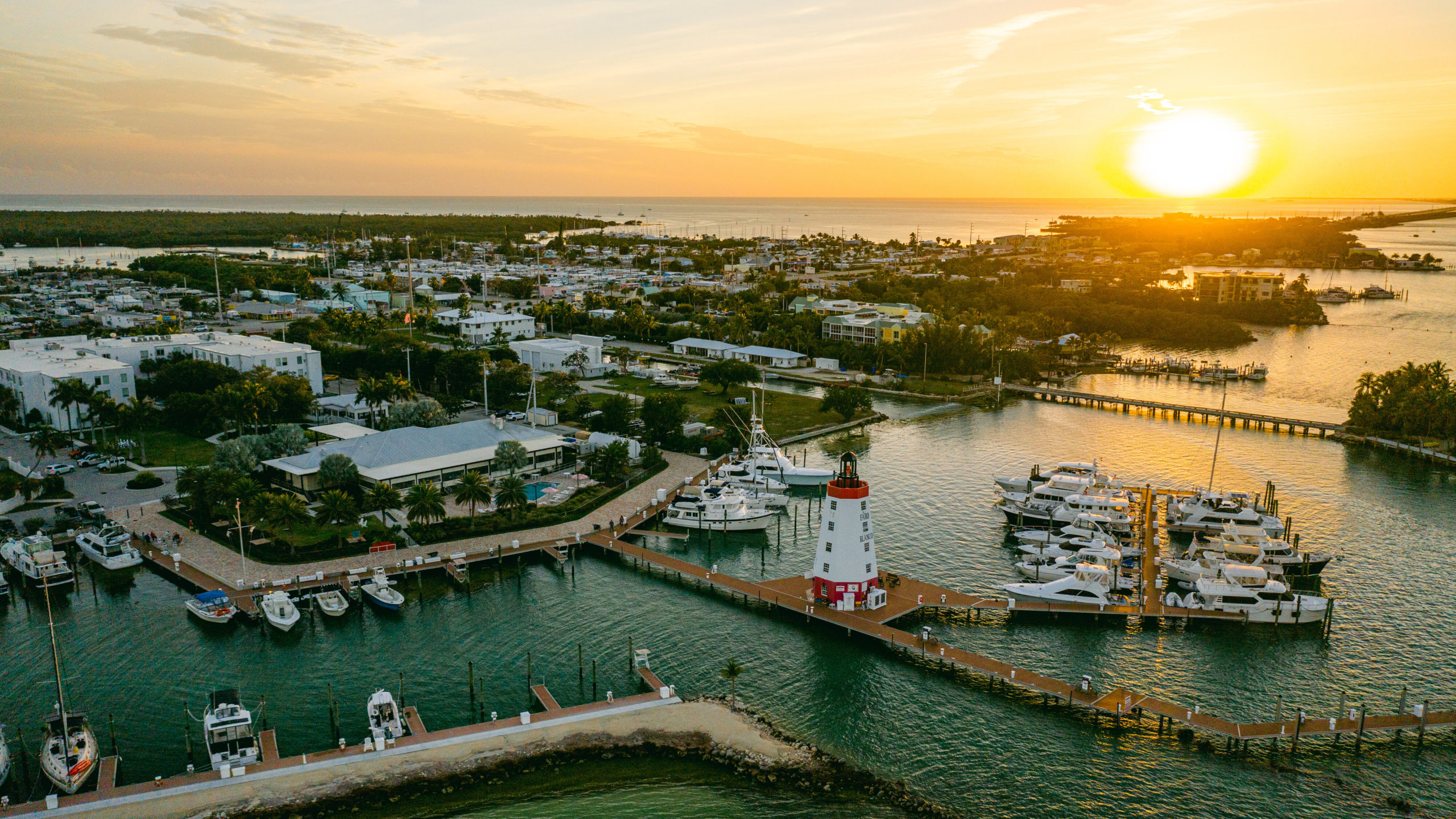 Sunset over Cobia Bay marina, docks, and lighthouse